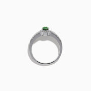 The 18K White Gold Alexandrite and Diamond Split Halo Ring showcases a central oval green Alexandrite, surrounded by a diamond halo with additional diamonds set along the band.