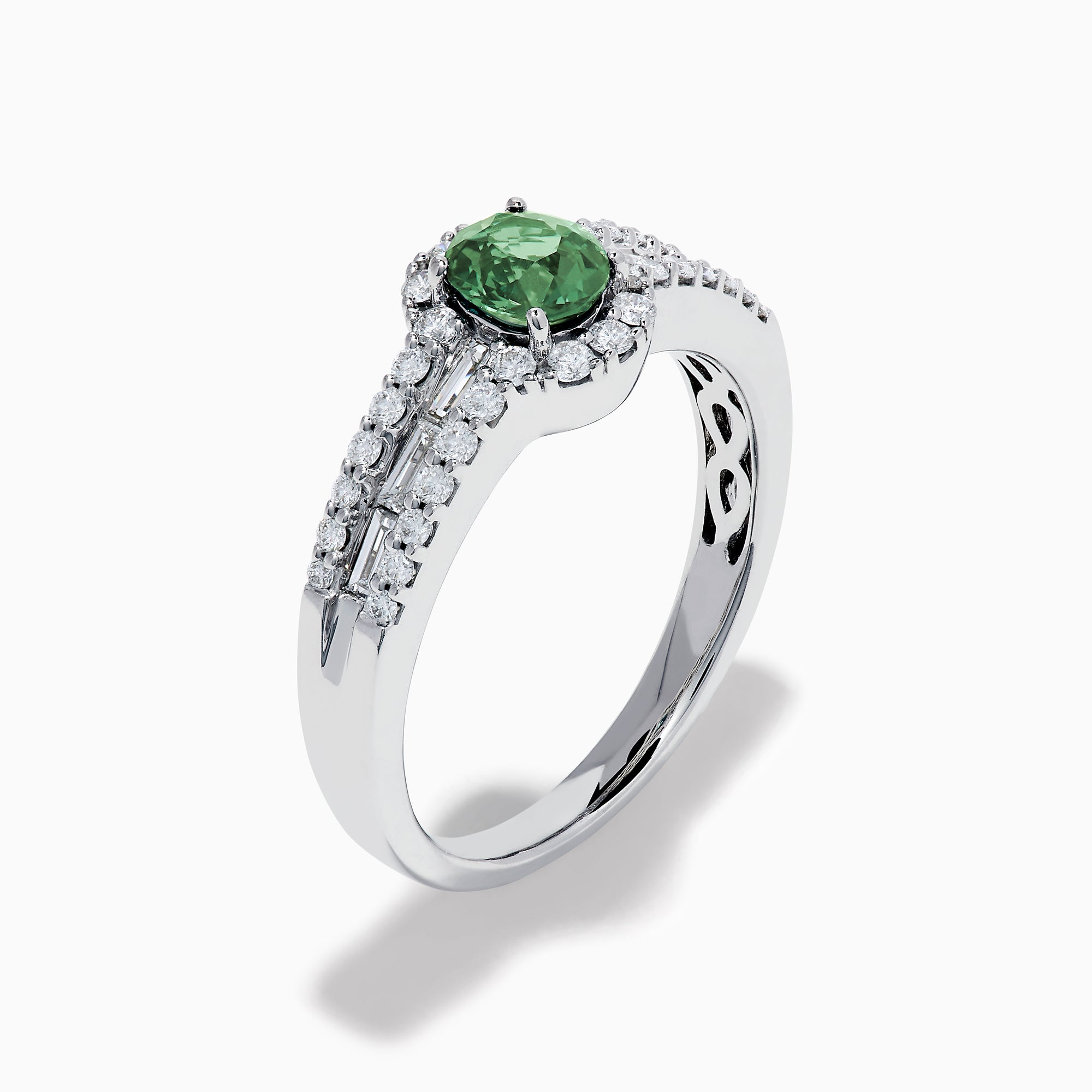 The 18K White Gold Alexandrite and Diamond Split Halo Ring showcases a central oval green Alexandrite, surrounded by a diamond halo with additional diamonds set along the band.