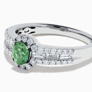 The 18K White Gold Alexandrite and Diamond Split Halo Ring showcases a central oval green Alexandrite, surrounded by a diamond halo with additional diamonds set along the band.