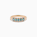 The 18K Rose Gold Alexandrite and Diamond Ring features five oval alexandrites, each encircled by sparkling white diamonds, showcased against a white background.