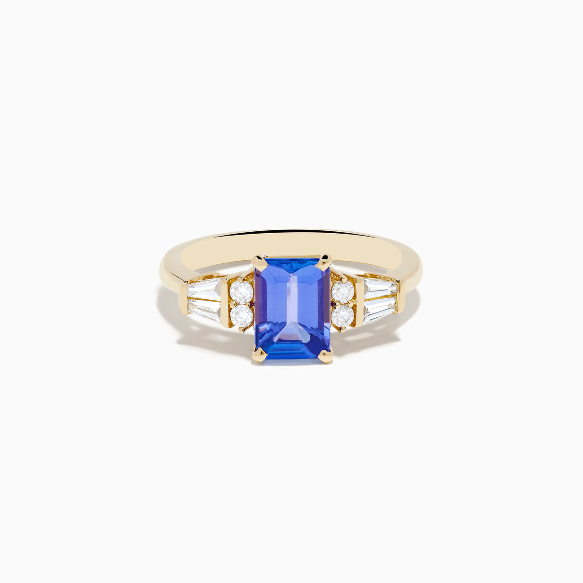 The Nahla 14K Yellow Gold Tanzanite and Diamond Ring showcases a rectangular blue tanzanite center, with two round diamonds and two baguette-cut white stones on each side, displayed on a white background.