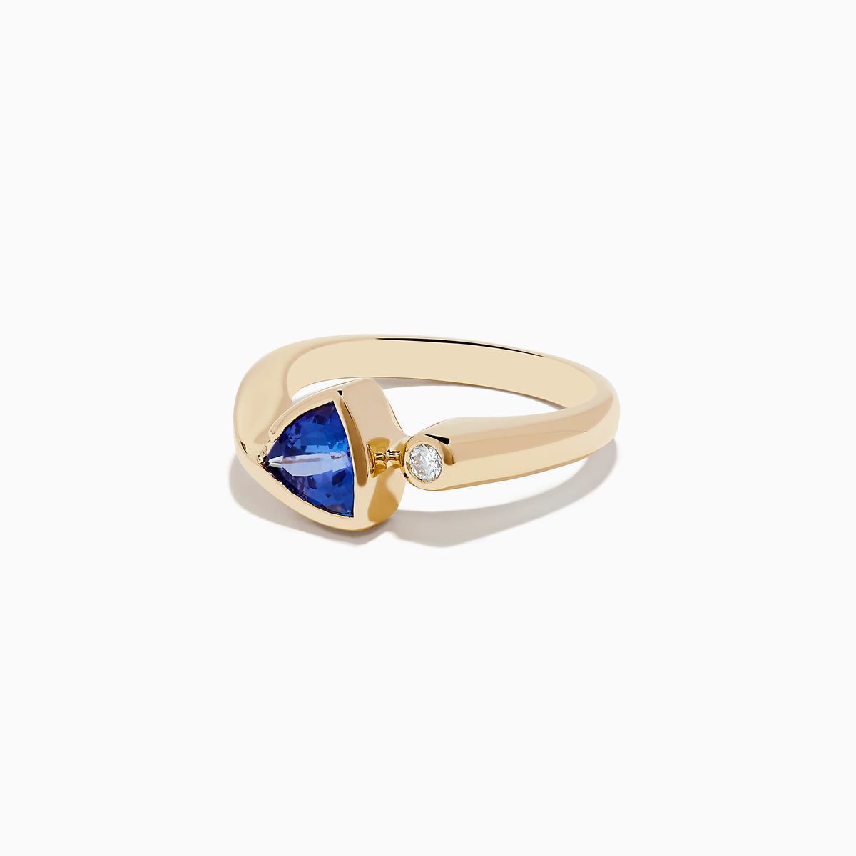 The Nahla Siri 14K Yellow Gold Tanzanite and Diamond Ring features a triangular blue tanzanite and a small round diamond, shown on a plain white background.