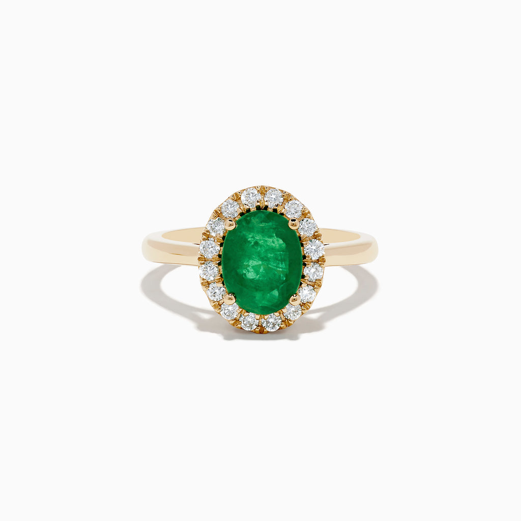 The 14K Yellow Gold Emerald and Diamond Ring features an oval green emerald center stone encircled by a halo of small round white diamonds, shown against a white background.