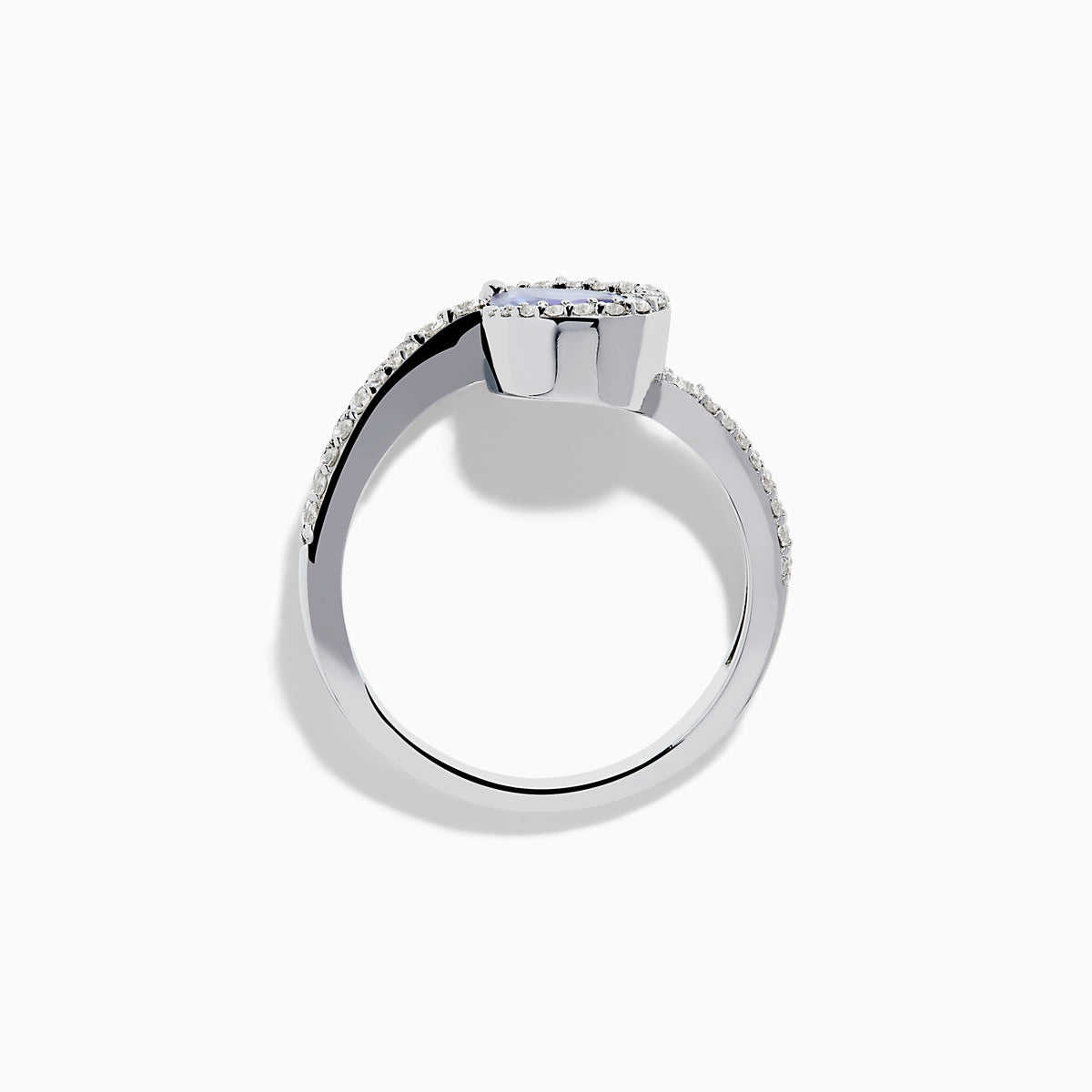 The Nahla 14K White Gold Tanzanite and Diamond Pear Swirl Ring showcases a pear-shaped blue tanzanite center, haloed by diamonds and accented with diamonds along a sweeping band.
