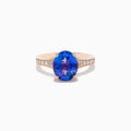 The Nahla 14K Rose Gold Tanzanite and Diamond Ring showcases an oval-cut blue tanzanite centerpiece accented by round diamonds on the band, set against a white background.