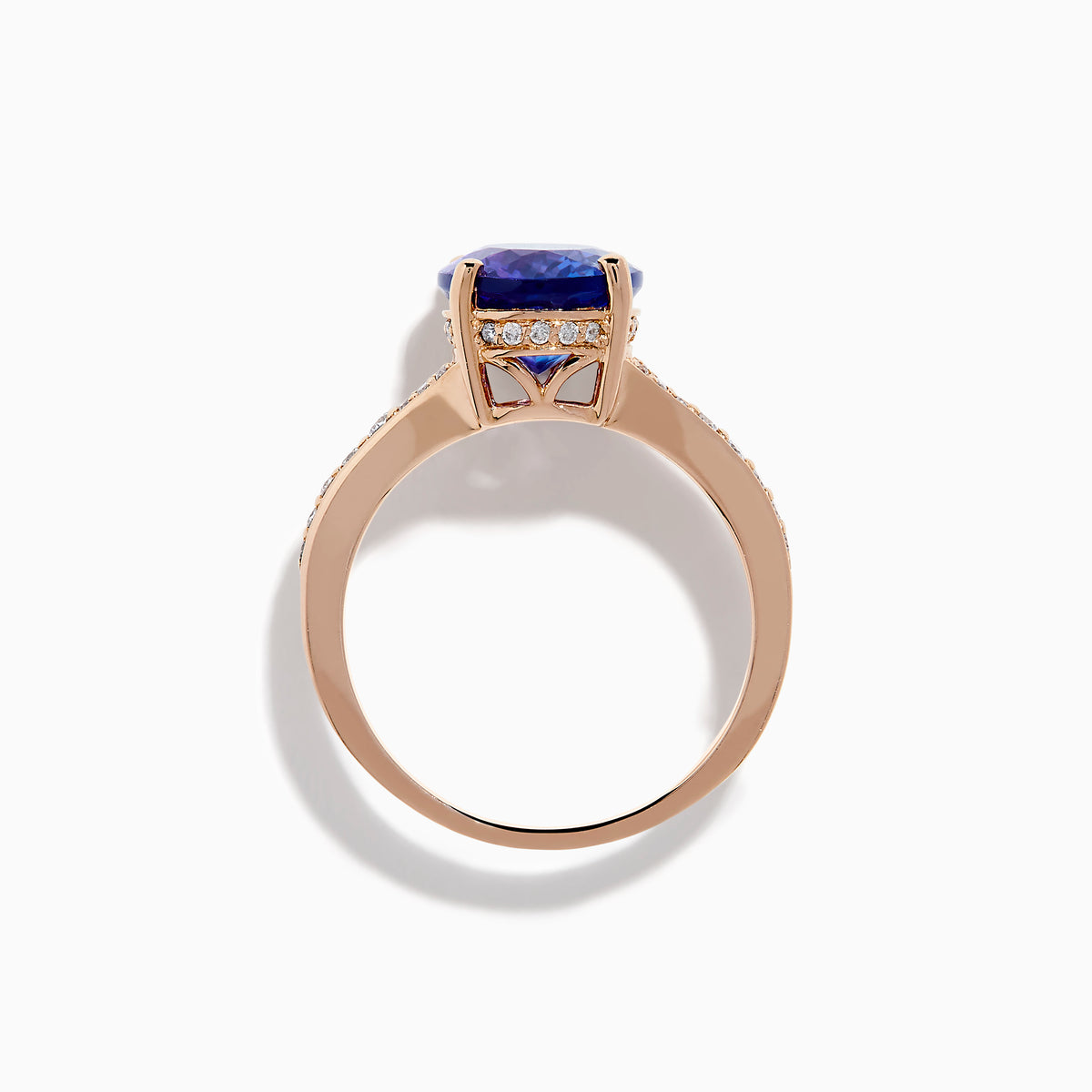 The Nahla 14K Rose Gold Tanzanite and Diamond Ring showcases an oval-cut blue tanzanite centerpiece accented by round diamonds on the band, set against a white background.