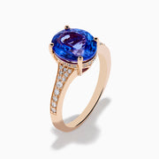 The Nahla 14K Rose Gold Tanzanite and Diamond Ring showcases an oval-cut blue tanzanite centerpiece accented by round diamonds on the band, set against a white background.