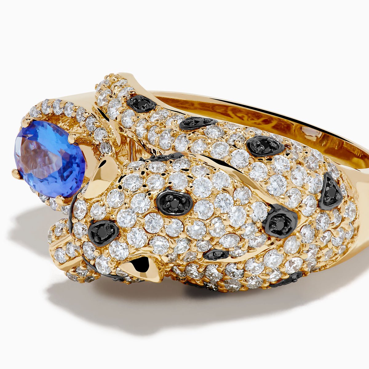 The Signature 14K Yellow Gold Tanzanite and Diamond Panther Ring showcases a sculpted panther with green gemstone eyes, diamond and black stone accents, holding an oval tanzanite gemstone.