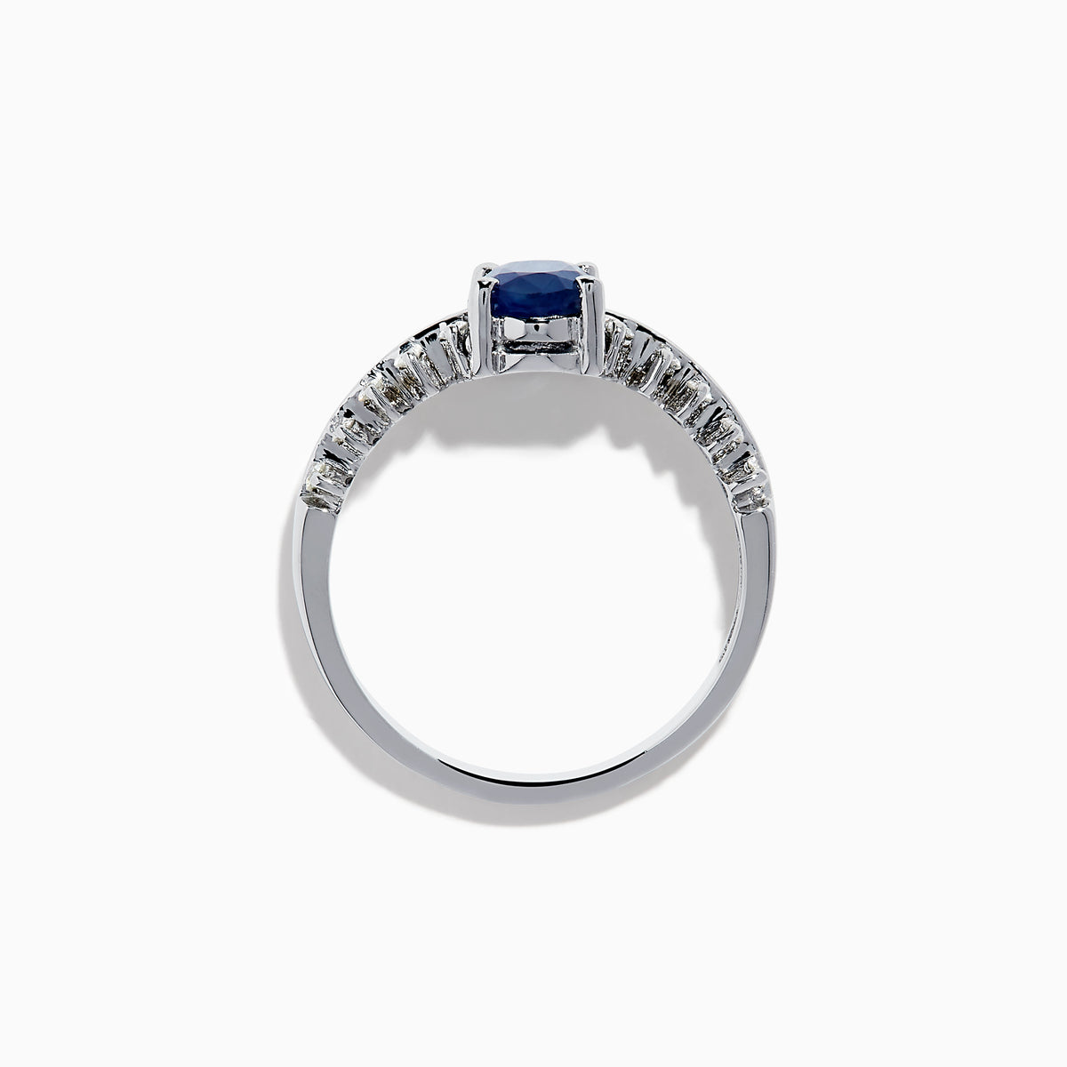 The 14K White Gold Blue Sapphire and Diamond Ring showcases an oval blue sapphire center, accented by two rows of round diamonds on each side, elegantly set against a white background.
