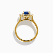 The Royale Bleu 18K Yellow Gold Blue Sapphire and Diamond Halo Ring showcases a striking oval blue sapphire centerpiece surrounded by a sparkling diamond halo.