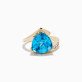 The Ocean Bleu 14K Yellow Gold Diamond, Blue Topaz Ring features a striking pear-shaped blue gemstone at its center, accented by diamonds on a sleek yellow gold band, displayed against a white background.