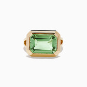 The 14K Yellow Gold Green Amethyst Ring features a striking emerald-cut gemstone in a simple, thick gold band, showcased on a white background.