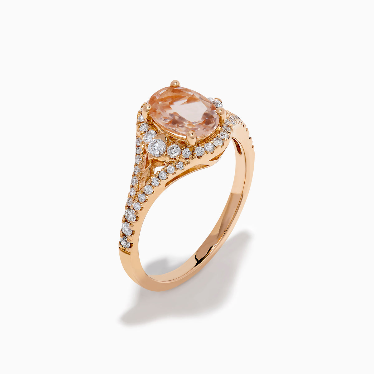 The Rose Gold Morganite and Diamond Split Halo Ring showcases an oval peach-colored Morganite center, encircled by a sparkling diamond split halo with additional diamonds along the band.
