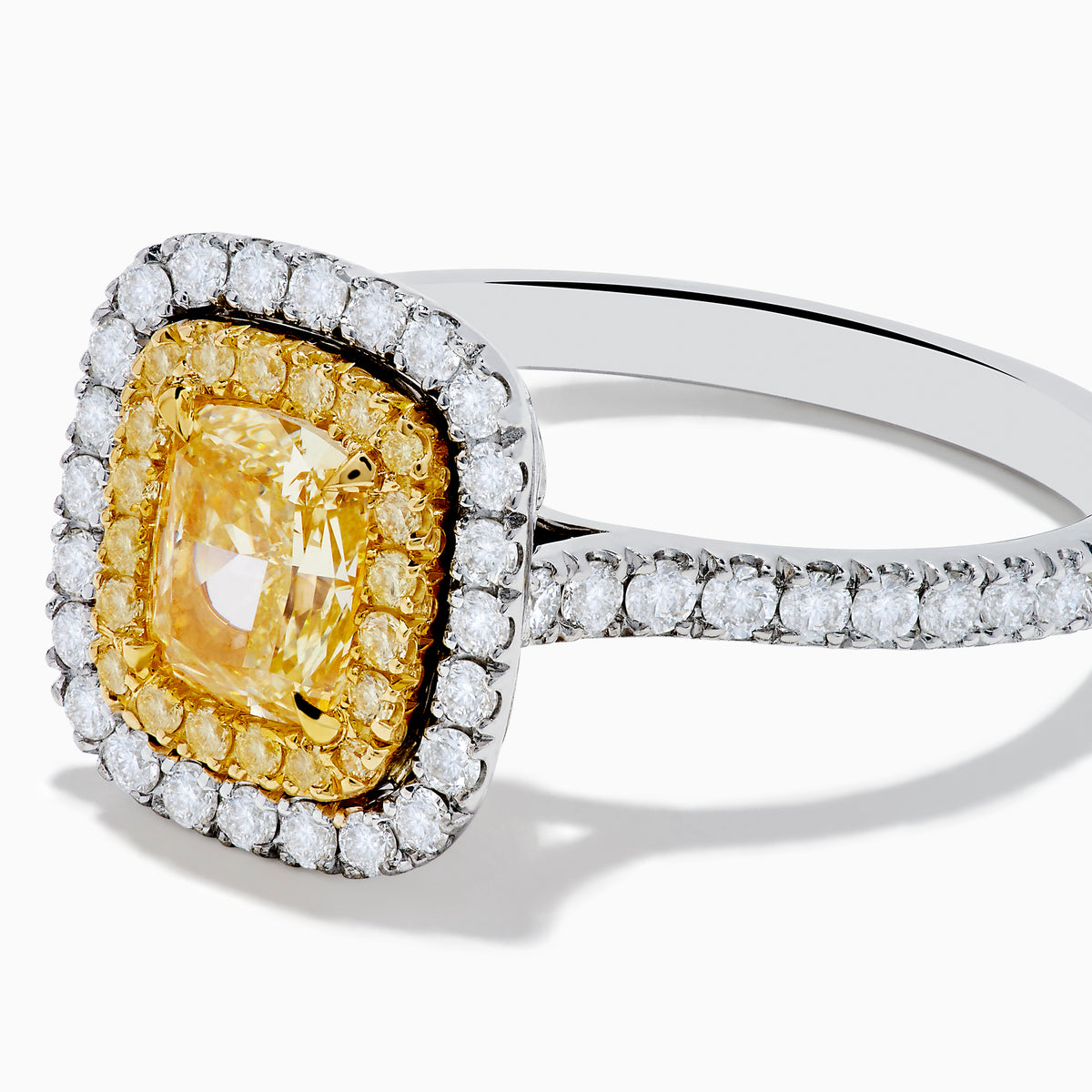 The 18K Two Toned Gold GIA certified Yellow and White Diamond Halo Ring features a rectangular yellow center stone, double halos of white diamonds, and extra diamonds along the band for exceptional brilliance.