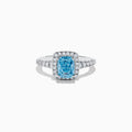 The 14K White Gold Lab Grown Blue and White Diamond Ring showcases a rectangular blue gemstone at its center, encircled by a halo of lab grown diamonds and more diamonds set along the band for extra sparkle.