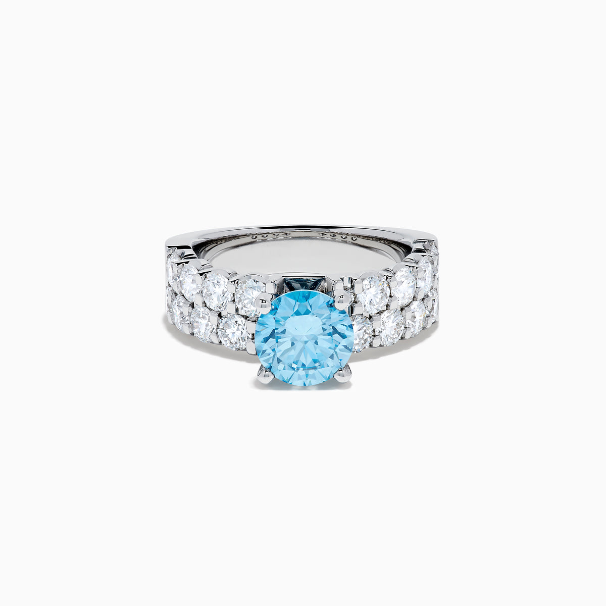 The Lab Grown Blue Diamond Round Brilliant Solitaire Ring in 14K White Gold features a striking round blue diamond center, accented by two rows of sparkling clear diamonds along the band, shown on a white background.