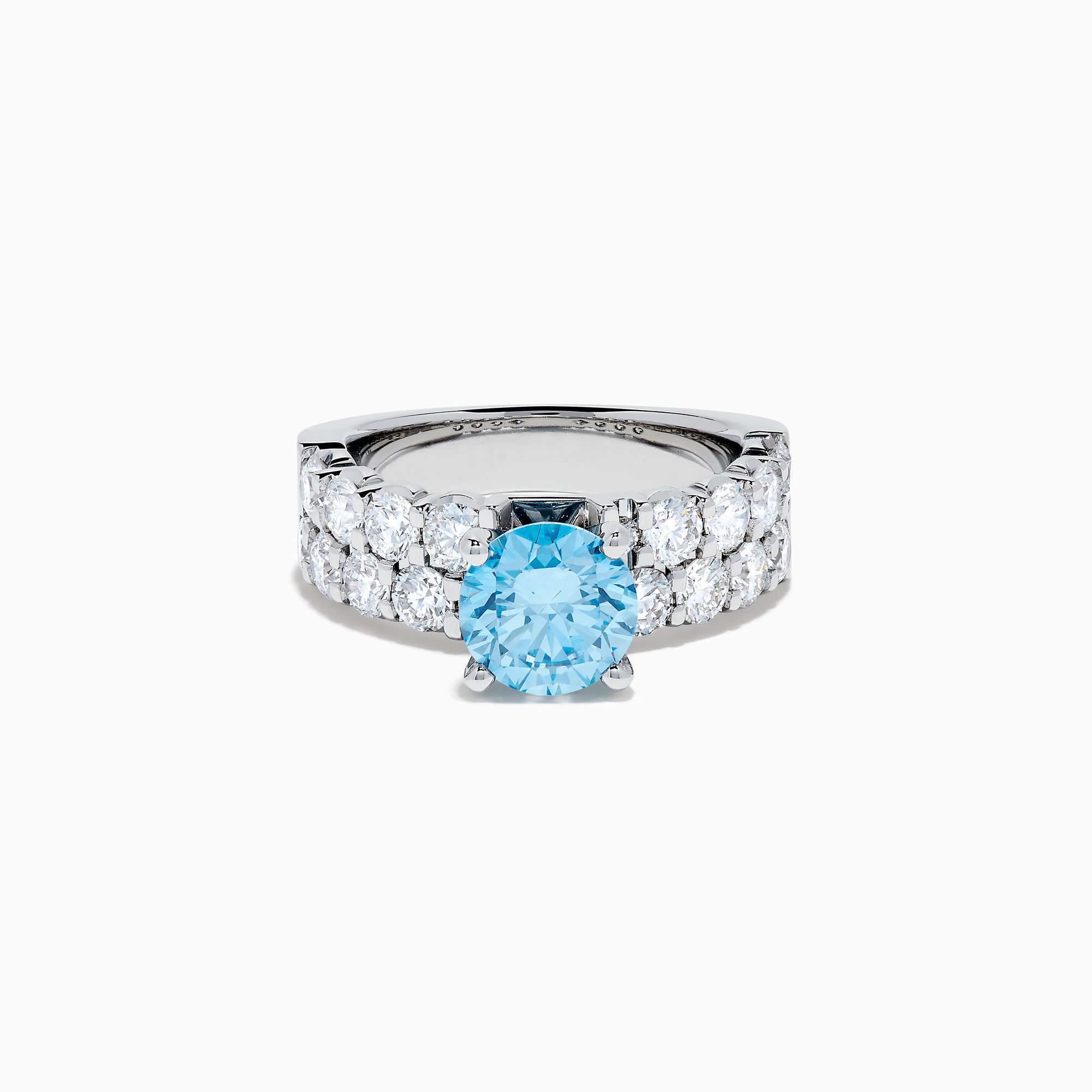 The Lab Grown Blue Diamond Round Brilliant Solitaire Ring in 14K White Gold features a striking round blue diamond center, accented by two rows of sparkling clear diamonds along the band, shown on a white background.