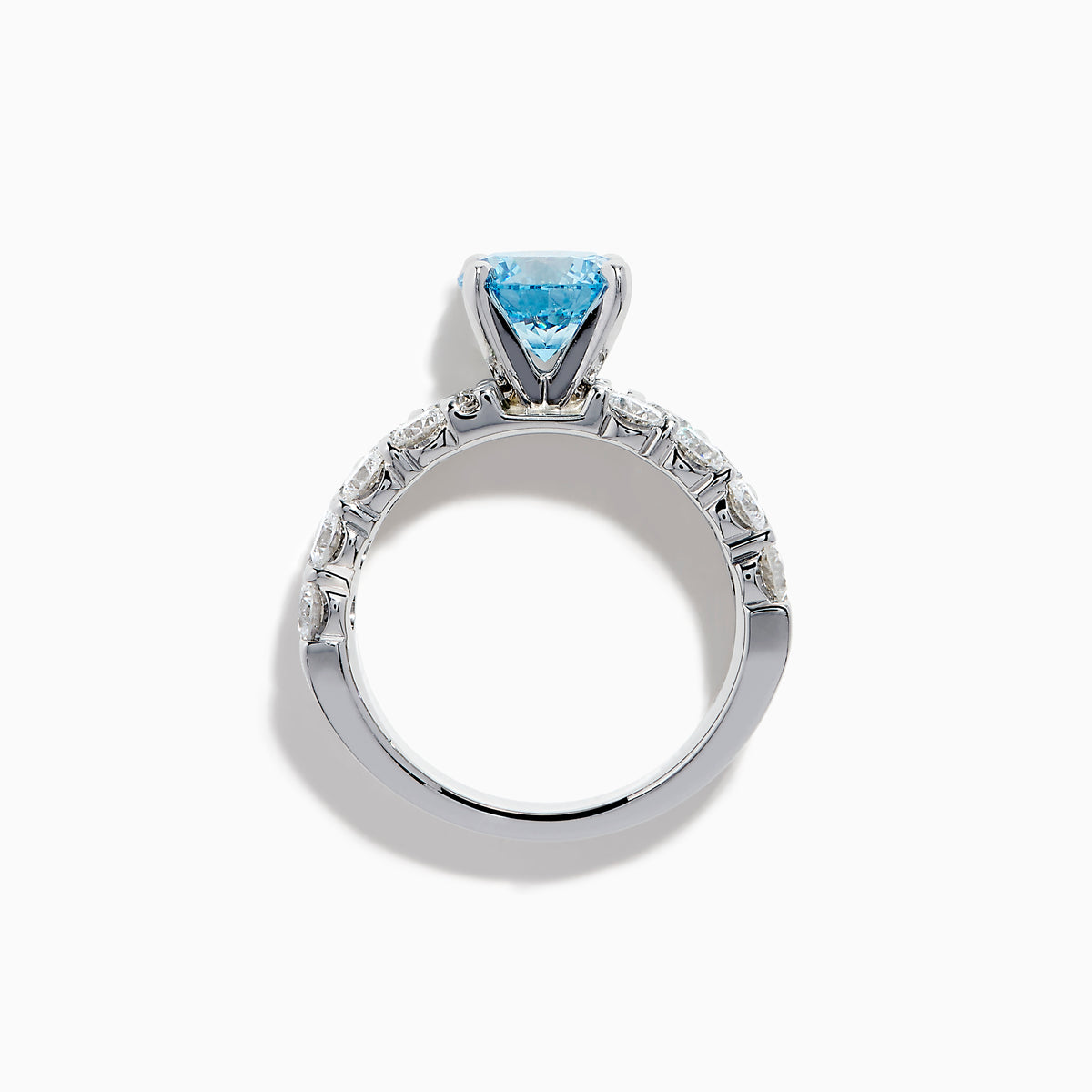 The Lab Grown Blue Diamond Round Brilliant Solitaire Ring in 14K White Gold features a striking round blue diamond center, accented by two rows of sparkling clear diamonds along the band, shown on a white background.