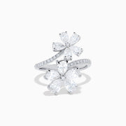 The Lab Grown Pear and Round Diamond 2.75ct Flower Bypass Ring in 14K White Gold features two flower designs with pear-shaped and round diamonds on a partially encrusted band, set against a white background for an elegant look.