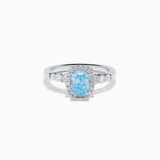 The Lab Grown Blue and White Diamond Halo Ring in 14K White Gold showcases a rectangular light blue center stone, surrounded by lab grown diamonds and accented with diamonds along the band for added sparkle.