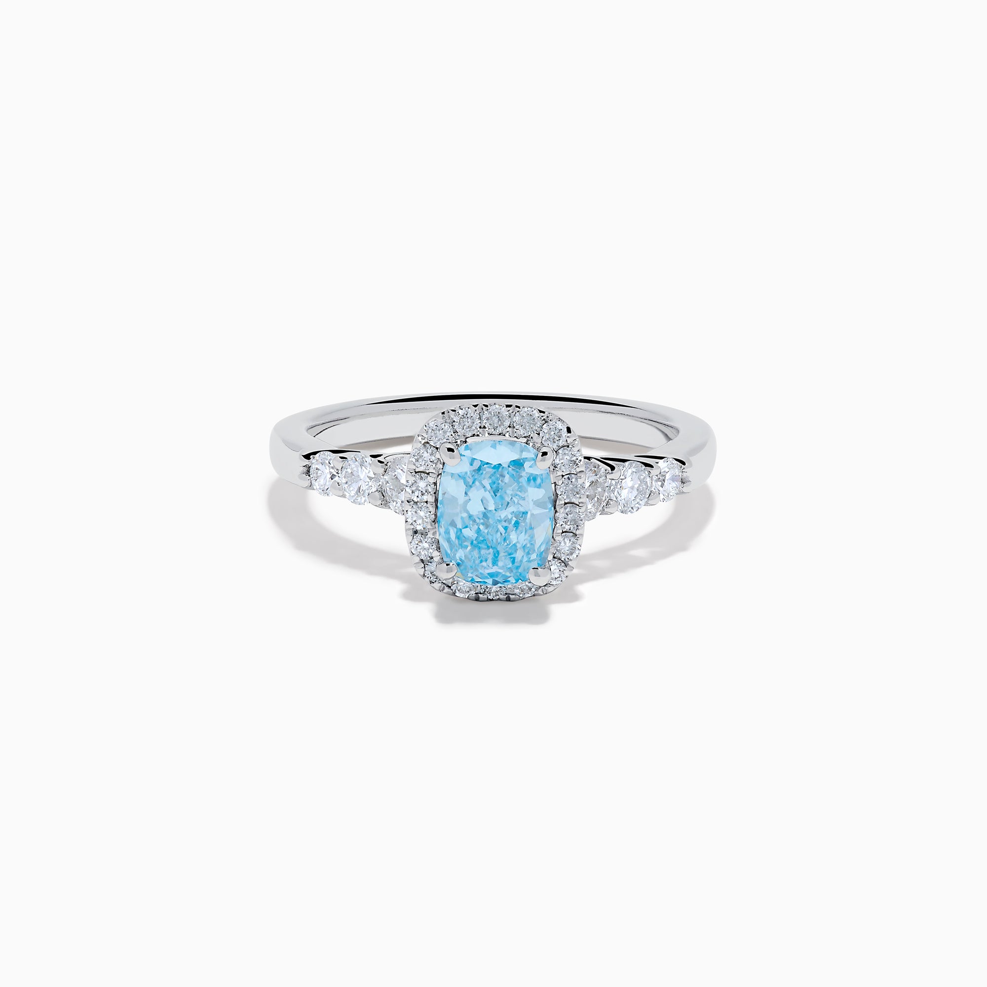 The Lab Grown Blue and White Diamond Halo Ring in 14K White Gold showcases a rectangular light blue center stone, surrounded by lab grown diamonds and accented with diamonds along the band for added sparkle.