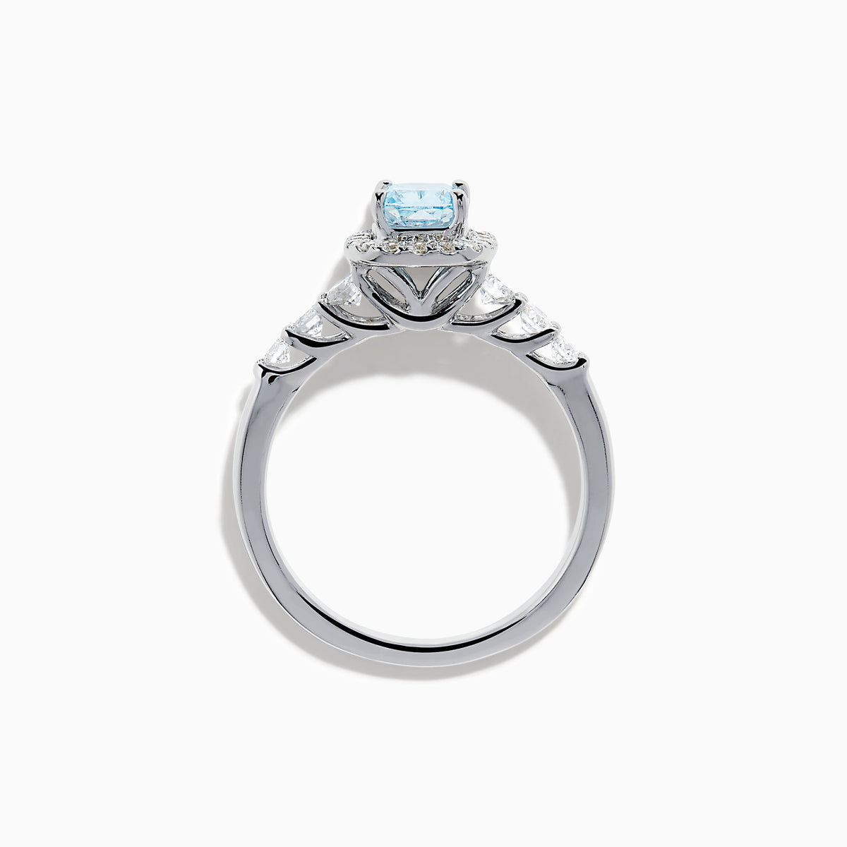 The Lab Grown Blue and White Diamond Halo Ring in 14K White Gold showcases a rectangular light blue center stone, surrounded by lab grown diamonds and accented with diamonds along the band for added sparkle.