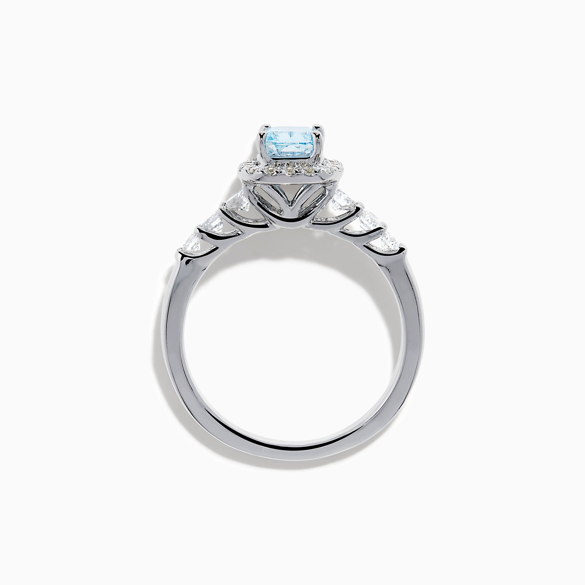 The Lab Grown Blue and White Diamond Halo Ring in 14K White Gold showcases a rectangular light blue center stone, surrounded by lab grown diamonds and accented with diamonds along the band for added sparkle.