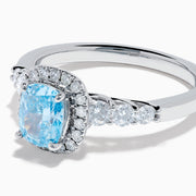 The Lab Grown Blue and White Diamond Halo Ring in 14K White Gold showcases a rectangular light blue center stone, surrounded by lab grown diamonds and accented with diamonds along the band for added sparkle.