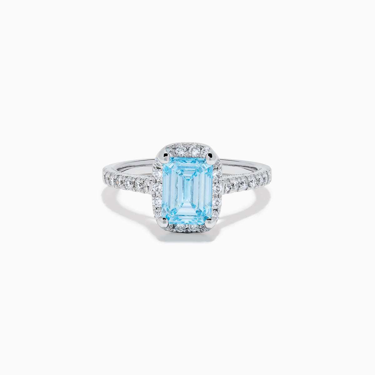 The Lab Grown Blue and White Diamond Halo Ring in 14K White Gold features an emerald-cut blue center stone with lab grown diamond accents, beautifully showcased on a white background.