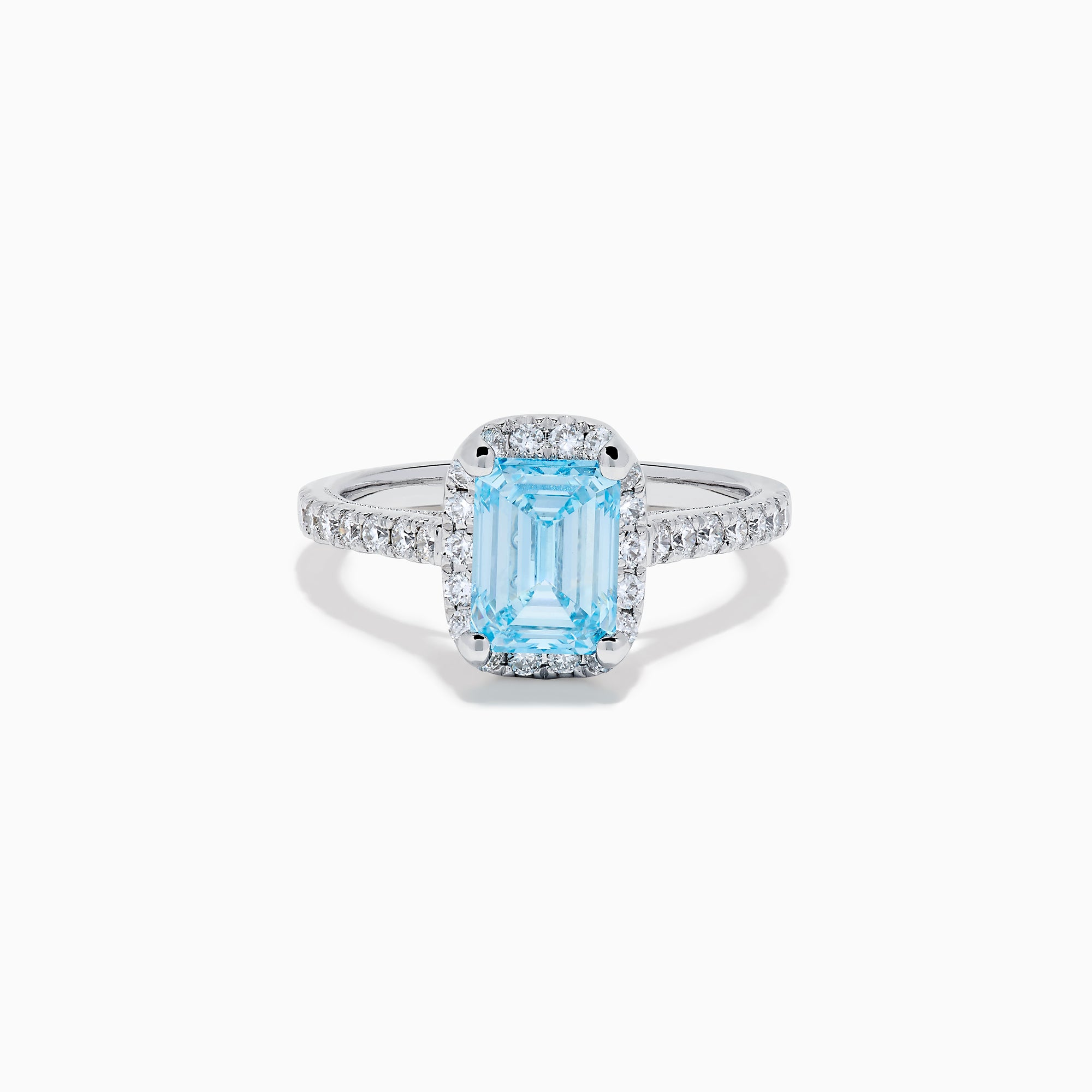The Lab Grown Blue and White Diamond Halo Ring in 14K White Gold features an emerald-cut blue center stone with lab grown diamond accents, beautifully showcased on a white background.