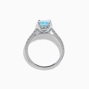 The Lab Grown Blue and White Diamond Halo Ring in 14K White Gold features an emerald-cut blue center stone with lab grown diamond accents, beautifully showcased on a white background.