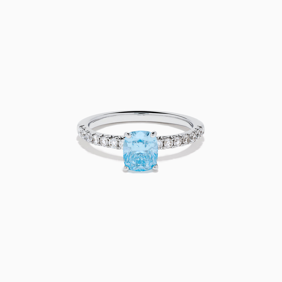 The Lab Grown Blue Diamond Solitaire Cushion Ring in 14K White Gold features a rectangular lab grown blue diamond at the center, accented with small clear round stones along the band.