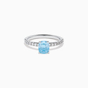 The Lab Grown Blue Diamond Solitaire Cushion Ring in 14K White Gold features a rectangular lab grown blue diamond at the center, accented with small clear round stones along the band.