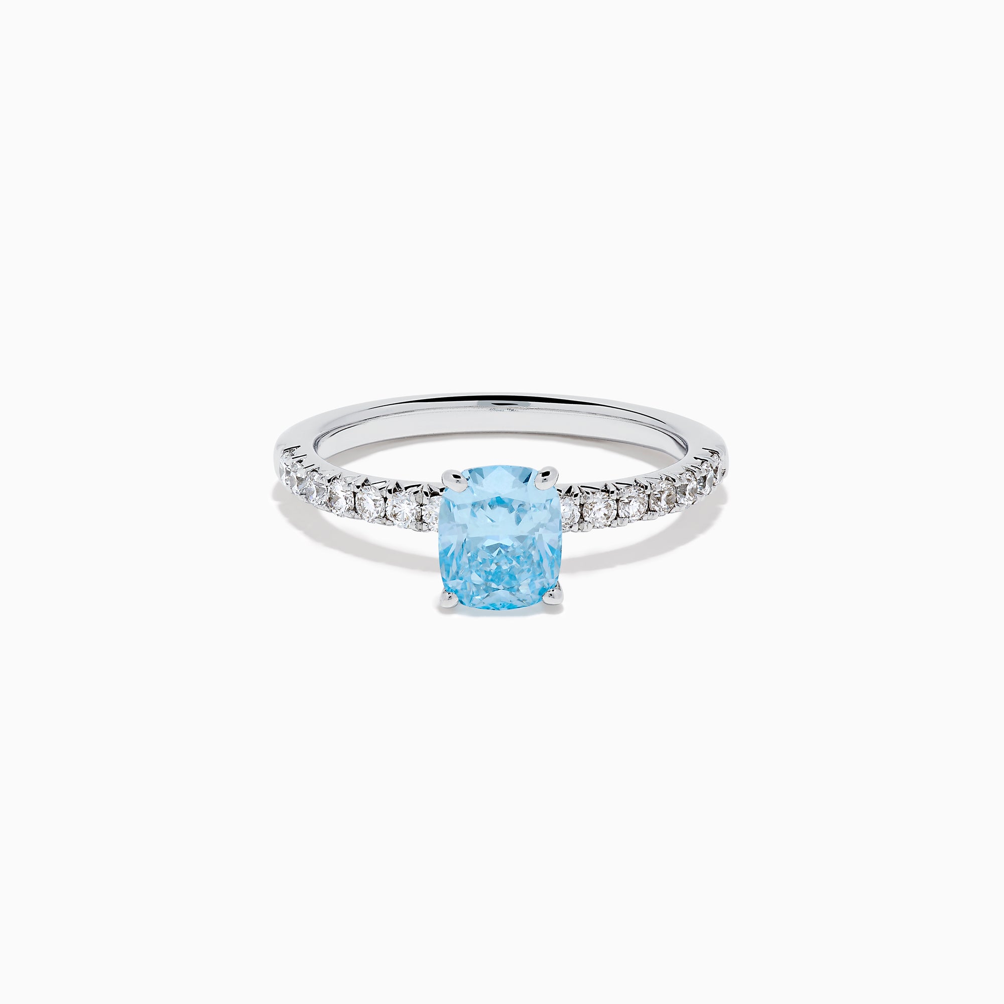 The Lab Grown Blue Diamond Solitaire Cushion Ring in 14K White Gold features a rectangular lab grown blue diamond at the center, accented with small clear round stones along the band.