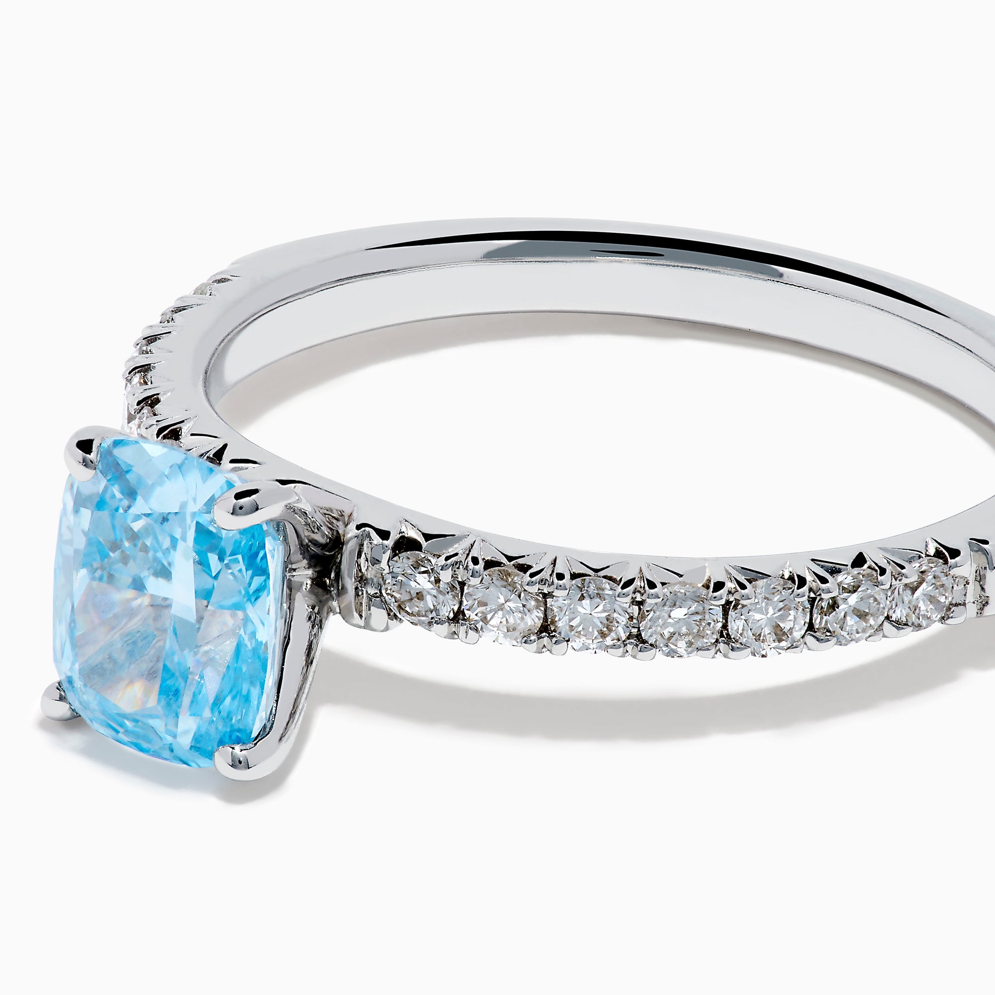 The Lab Grown Blue Diamond Solitaire Cushion Ring in 14K White Gold features a rectangular lab grown blue diamond at the center, accented with small clear round stones along the band.