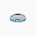 The Lab Grown Blue Diamond Channel Set Band in 14K White Gold features a row of round blue diamonds encircling the band, shown elegantly on a plain white background.