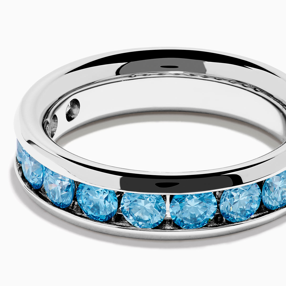 The Lab Grown Blue Diamond Channel Set Band in 14K White Gold features a row of round blue diamonds encircling the band, shown elegantly on a plain white background.