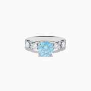 The 14K White Gold Lab Grown Blue and White Diamond Ring features a large round blue gemstone in the center, flanked by three smaller lab grown diamonds on each side, set against a plain white background.