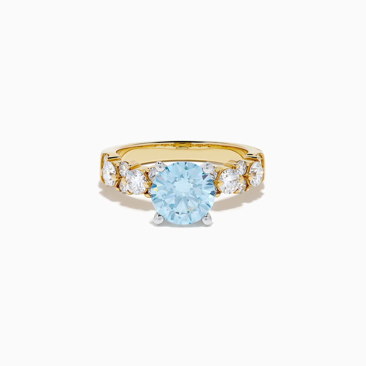The Lab Grown Blue and White Diamond Ring in 14K Yellow Gold showcases a large round light blue gemstone at the center, accented by three teardrop-shaped lab grown white diamonds on each side.