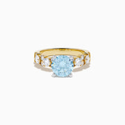 The Lab Grown Blue and White Diamond Ring in 14K Yellow Gold showcases a large round light blue gemstone at the center, accented by three teardrop-shaped lab grown white diamonds on each side.