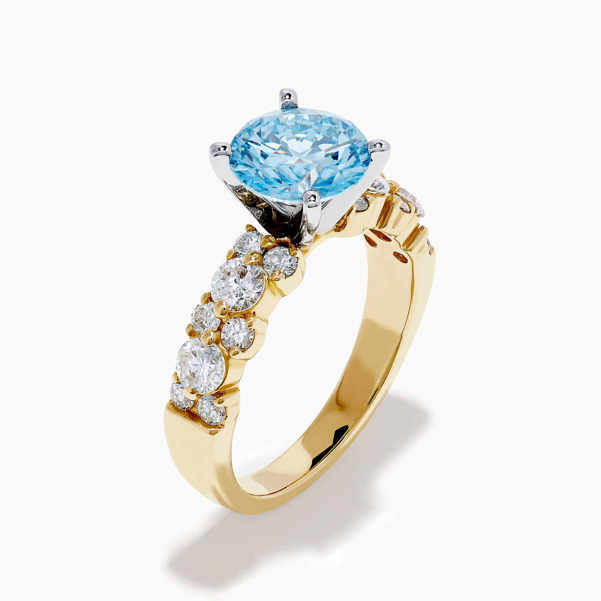 The Lab Grown Blue and White Diamond Ring in 14K Yellow Gold showcases a large round light blue gemstone at the center, accented by three teardrop-shaped lab grown white diamonds on each side.