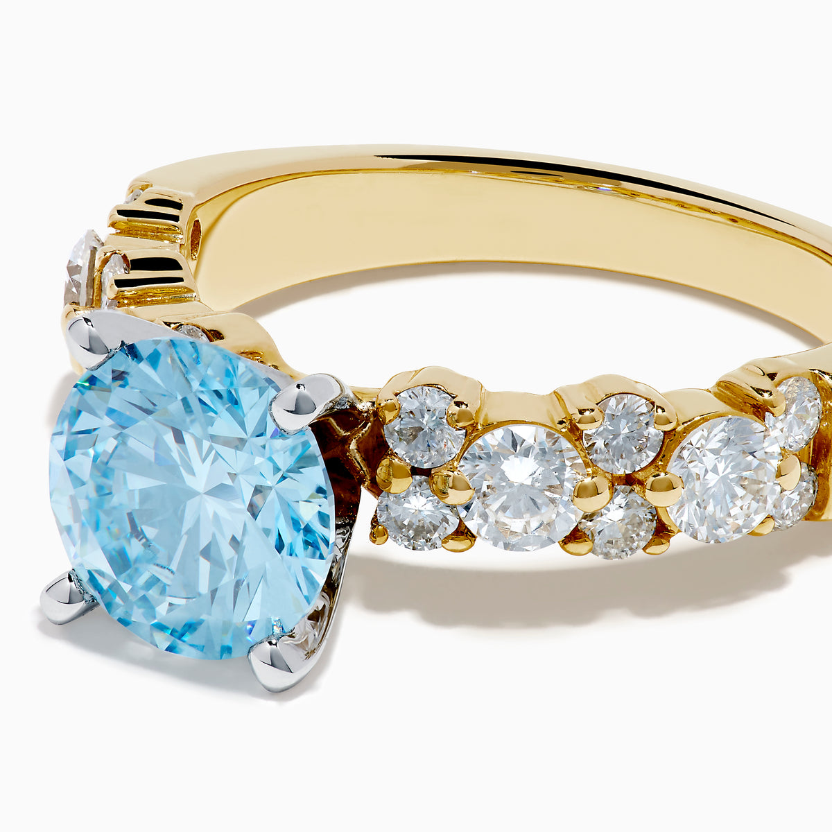 The Lab Grown Blue and White Diamond Ring in 14K Yellow Gold features a large round blue gemstone in a prong setting, accented by lab grown diamonds along the band.