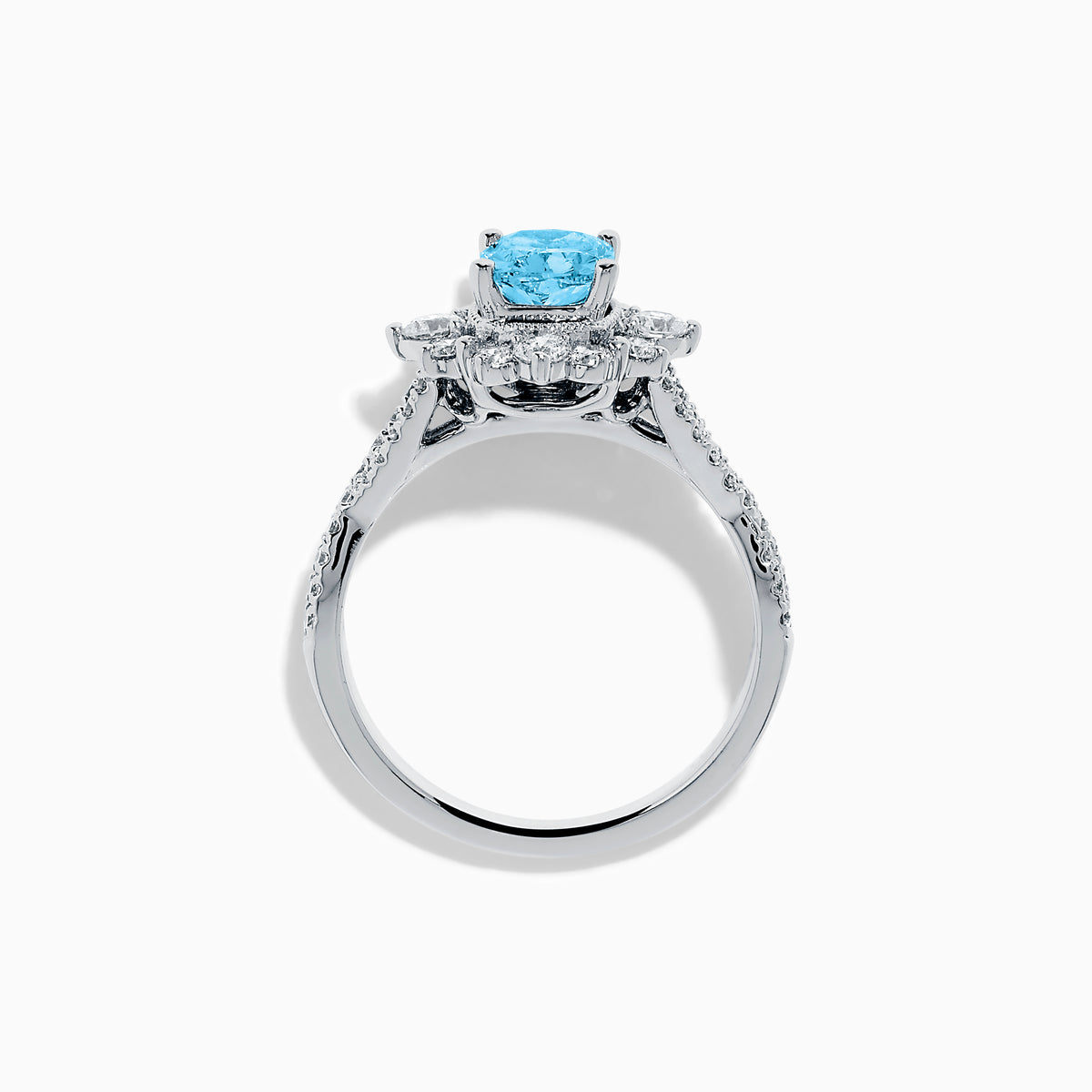 The Lab Grown Blue and White Diamond Ring in 14K White Gold showcases an oval blue gemstone surrounded by a halo of lab grown diamonds, with more diamonds accenting the band.