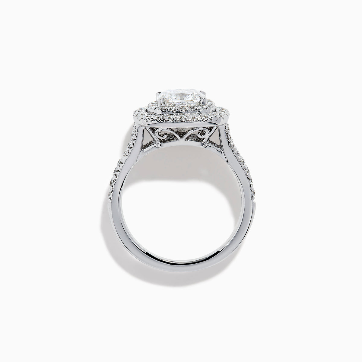 The Lab Grown Cushion Diamond Double Halo Ring in 14K White Gold features a cushion-cut center diamond, double halo of smaller diamonds, and additional diamonds along the band.