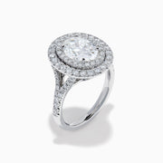 The Lab Grown Oval Diamond Double Halo Ring in 14K White Gold features a dazzling oval center, lab grown diamonds in a double halo, and extra sparkle along the band for an elegant look.