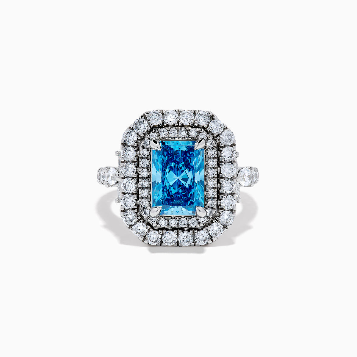 The Lab Grown Blue Diamond Double Halo Cocktail Ring in 14K White Gold features a rectangular blue center, round white diamonds on the band, and is displayed against a white background.