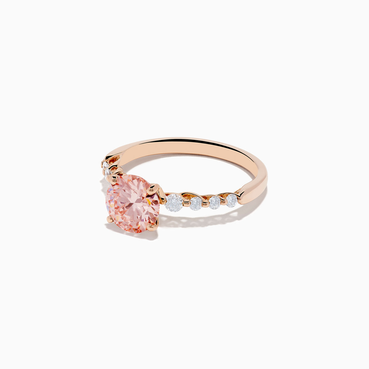 The 14K Rose Gold Lab Grown Pink and White Diamond Ring showcases a large round pink and white diamond centered between three smaller clear stones on each side, set against a plain white background.