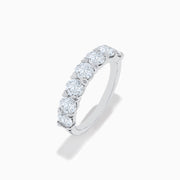 The Lab Grown Diamond Wedding Band in 14K White Gold showcases round, sparkling lab diamonds in a shared-prong setting on a sleek band, set against a white background.