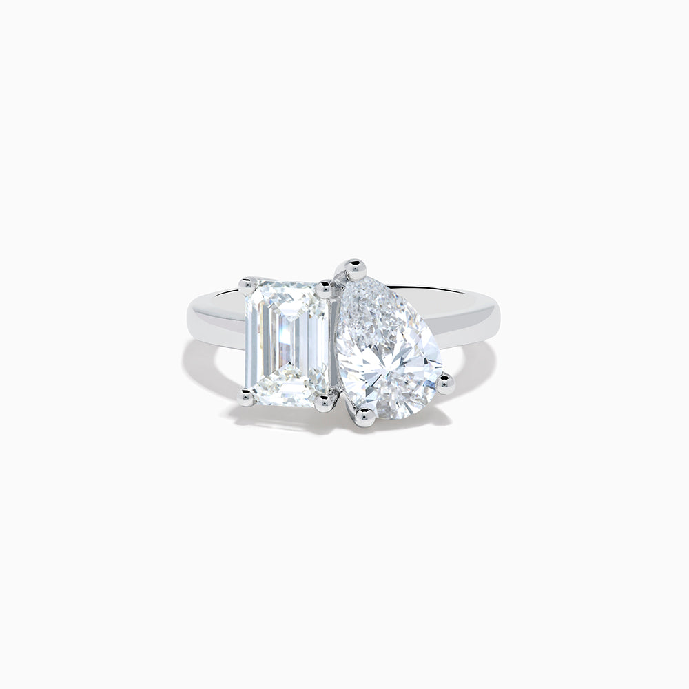 The Lab Grown Diamond Toi Et Moi Ring in 14K White Gold showcases emerald-cut and pear-shaped lab diamonds set side by side on a sleek band, displayed against a white background.