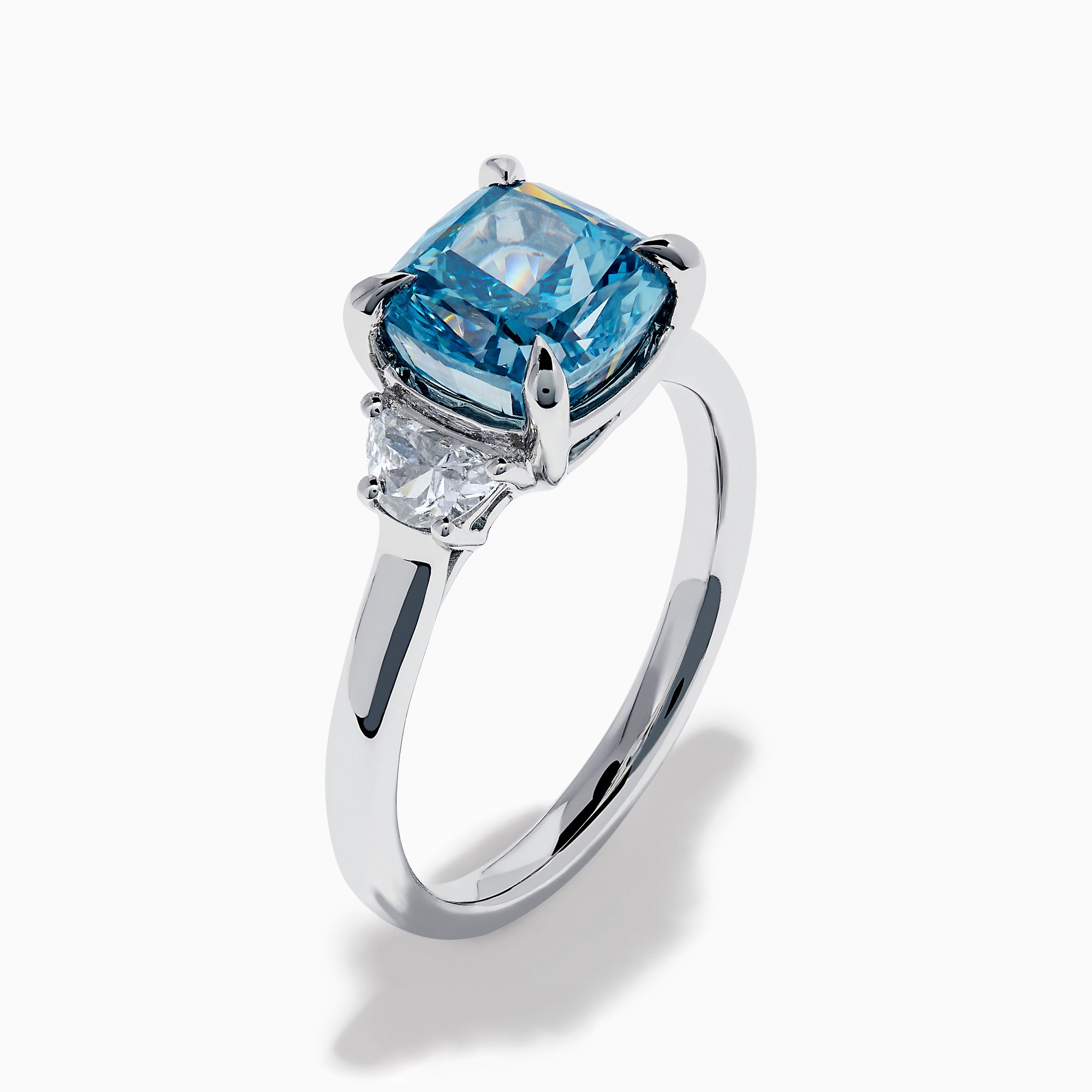 Lab Grown Blue and White Diamond 3-Stone Ring in 14K White Gold, featuring a prominent cushion-cut blue and white diamond center with two clear triangular side stones, shown on a white background.